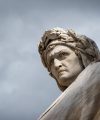 Closeup shot of the famous white marble monument of Dante Alighieri by  Enrico Pazzi in Piazza Santa Croce, next to Basilica of Santa Croce, Florence, Italy on a moody sky background